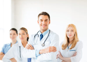 attractive male doctor in front of medical group